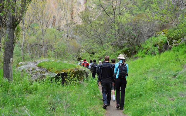 Group trekking through lush Ihlara Valley on Cappadocia Green Tour.