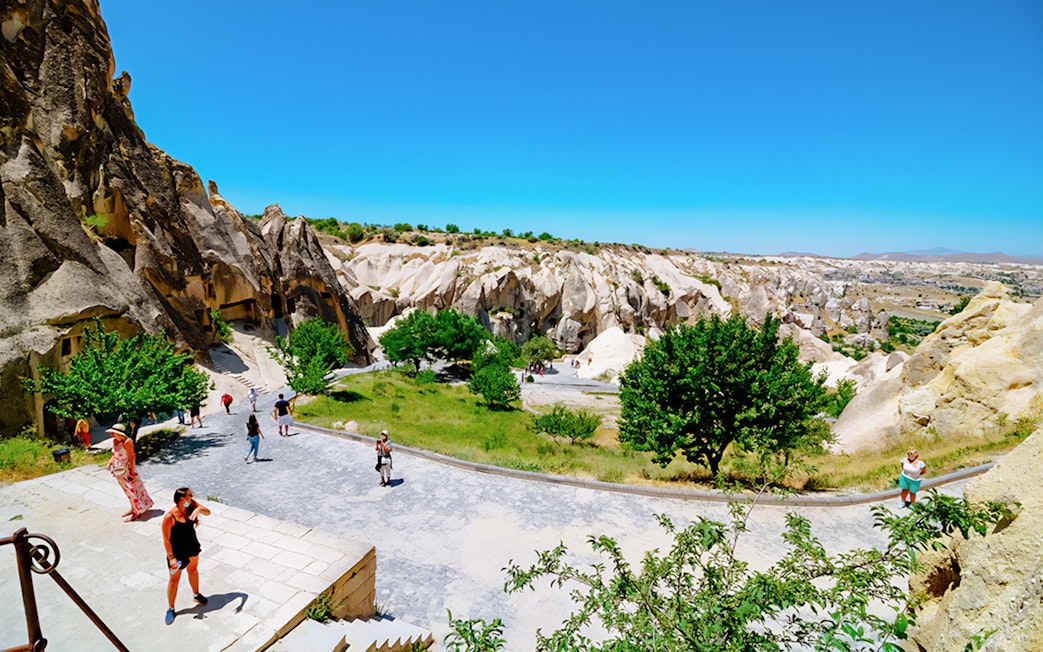 Visitors exploring Göreme Open-Air Museum with rock formations in Cappadocia.