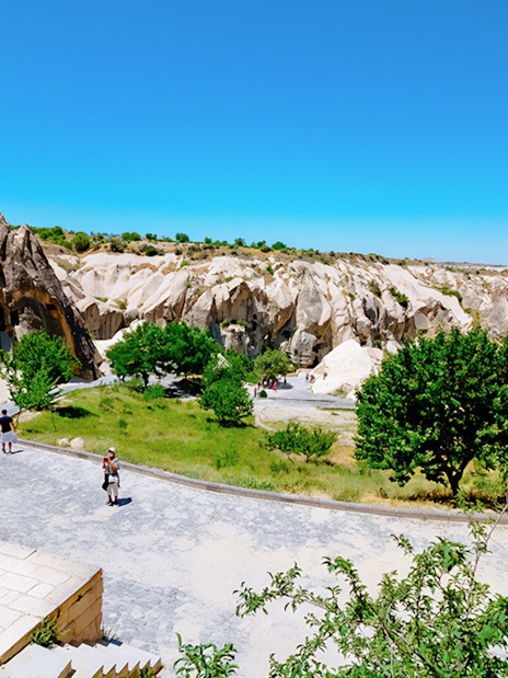 Visitors exploring Göreme Open-Air Museum with rock formations in Cappadocia.