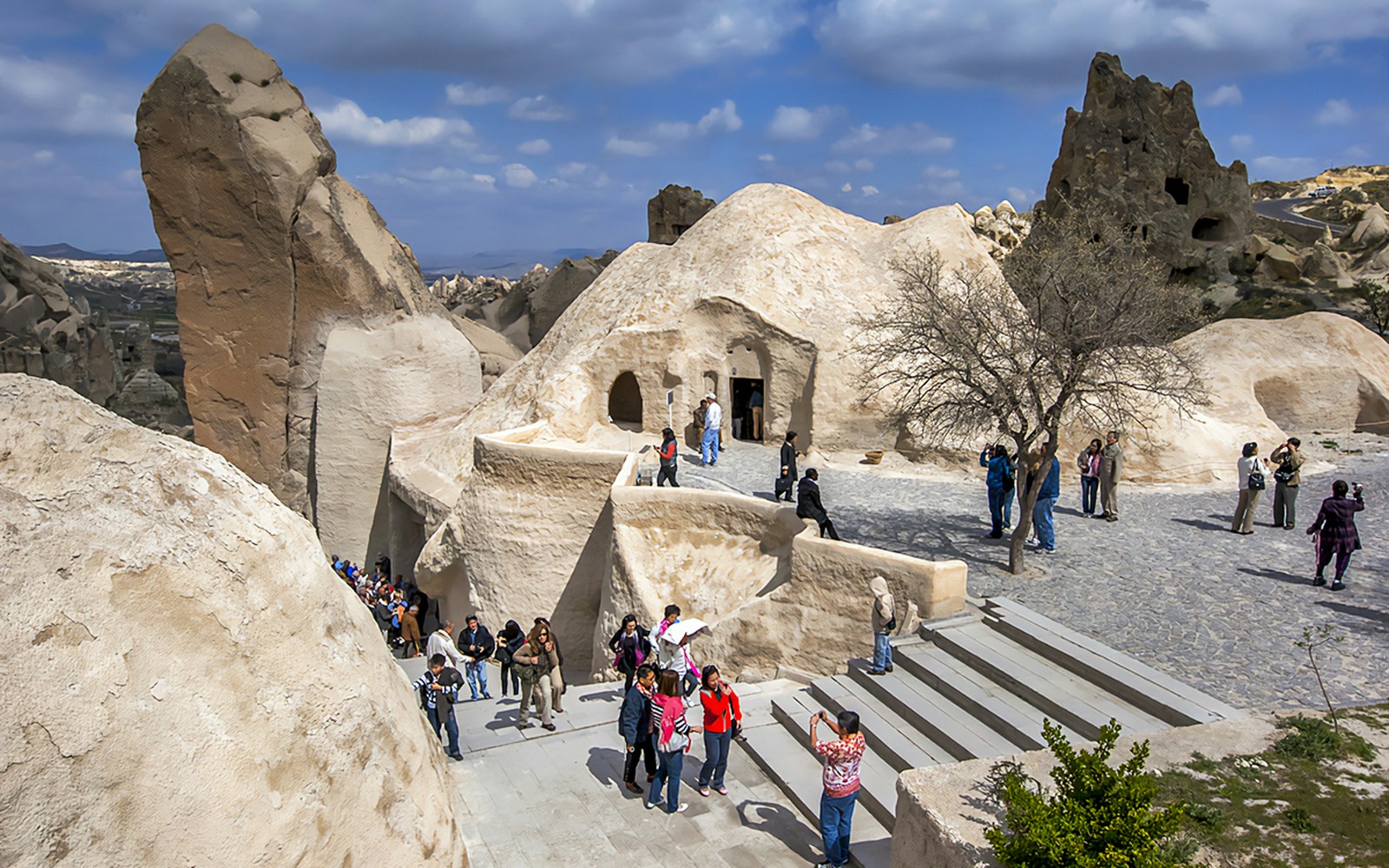 Visitors exploring rock formations at Göreme Open-Air Museum, Cappadocia.