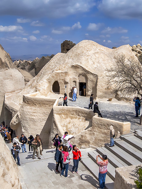 Visitors exploring rock formations at Göreme Open-Air Museum, Cappadocia.