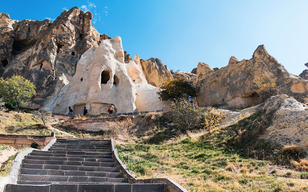 Göreme Open-Air Museum rock formations with tourists exploring, Cappadocia.