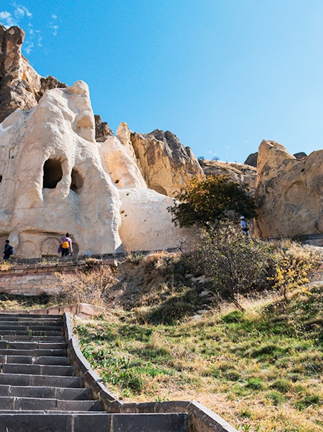 Göreme Open-Air Museum rock formations with tourists exploring, Cappadocia.
