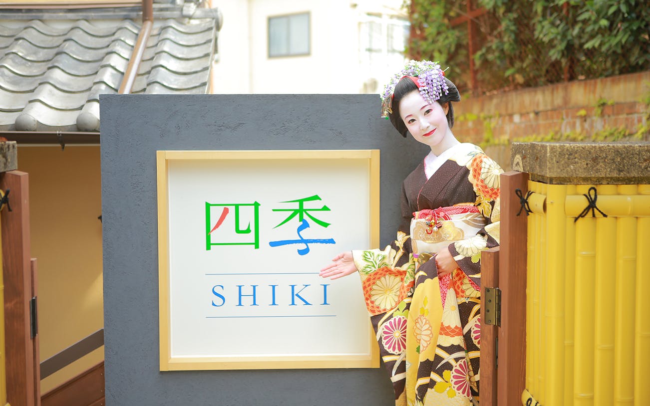 Maiko in traditional attire at Shiki sign, Kyoto.