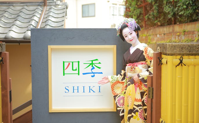 Maiko in traditional attire at Shiki sign, Kyoto.