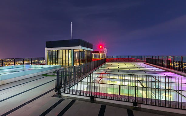 Rooftop view from The Shore Sky Tower at night with city lights in the background.