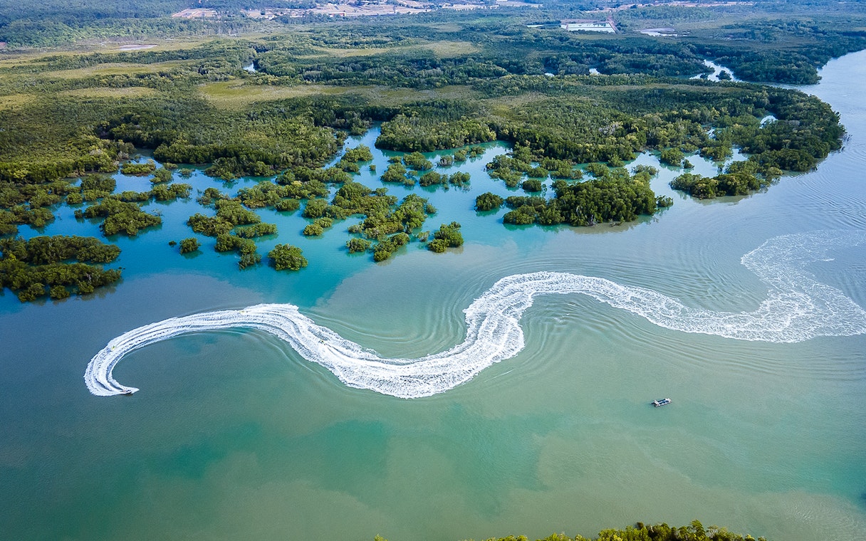 Jet ski creating wake trails in mangrove waters, Darwin.