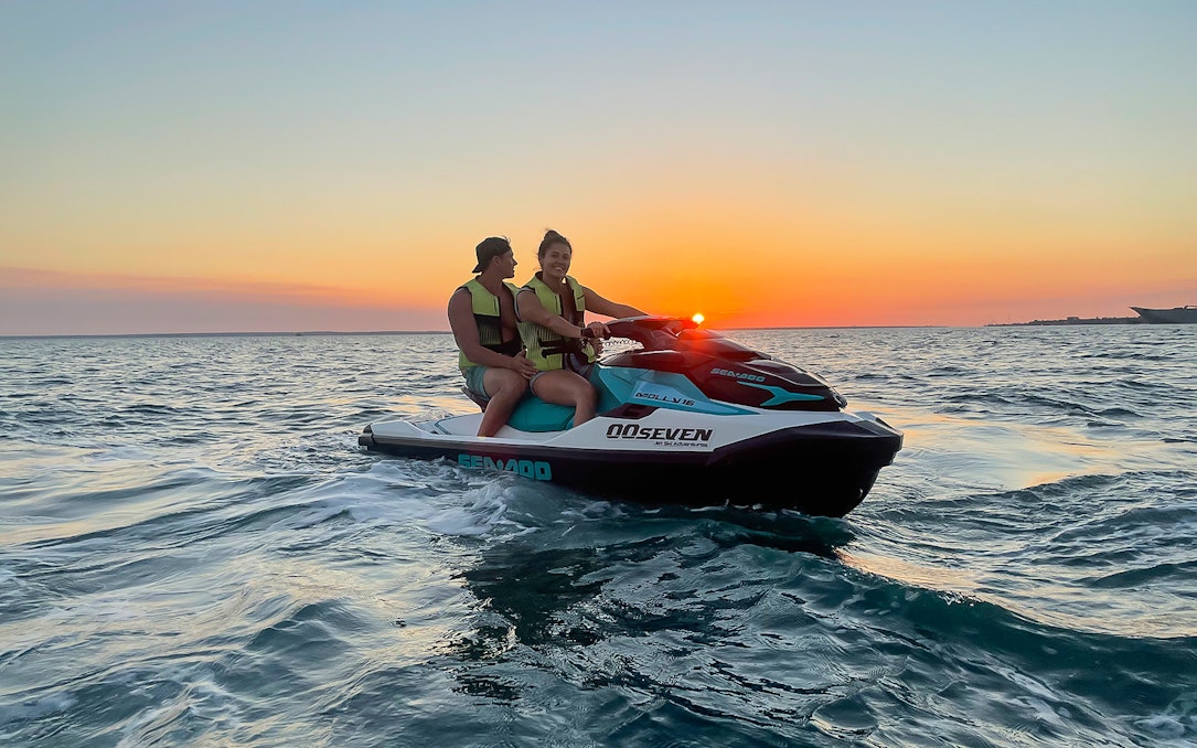 Two people on a jet ski during sunset on a Darwin tour.