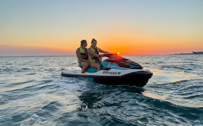 Two people on a jet ski during sunset on a Darwin tour.