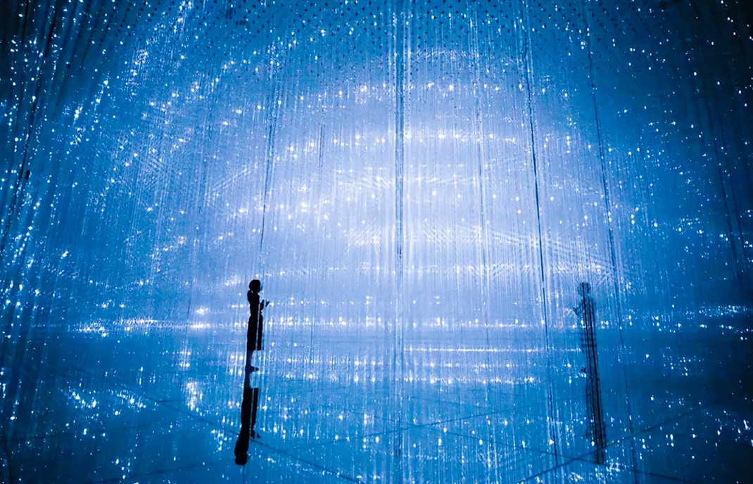 Visitors interacting with digital art installation at TeamLab Planets Tokyo.