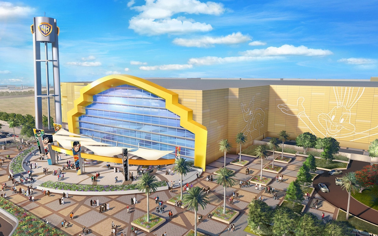 Warner Bros World Abu Dhabi entrance with iconic character murals and visitors.