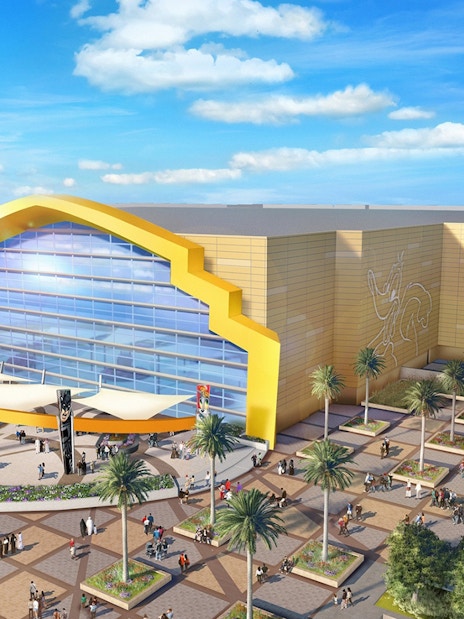 Warner Bros World Abu Dhabi entrance with iconic character murals and visitors.