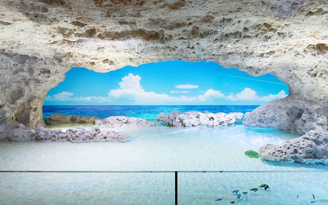 Rocky cave with view of ocean and sky at DMM Kariyushi Aquarium.