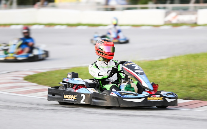 Go-kart racing at Morac Adventure Park, Langkawi, with driver navigating a track curve.