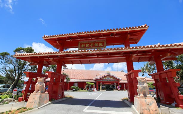 Red entrance gate of Ryukyu Village in Okinawa on a sightseeing bus tour.