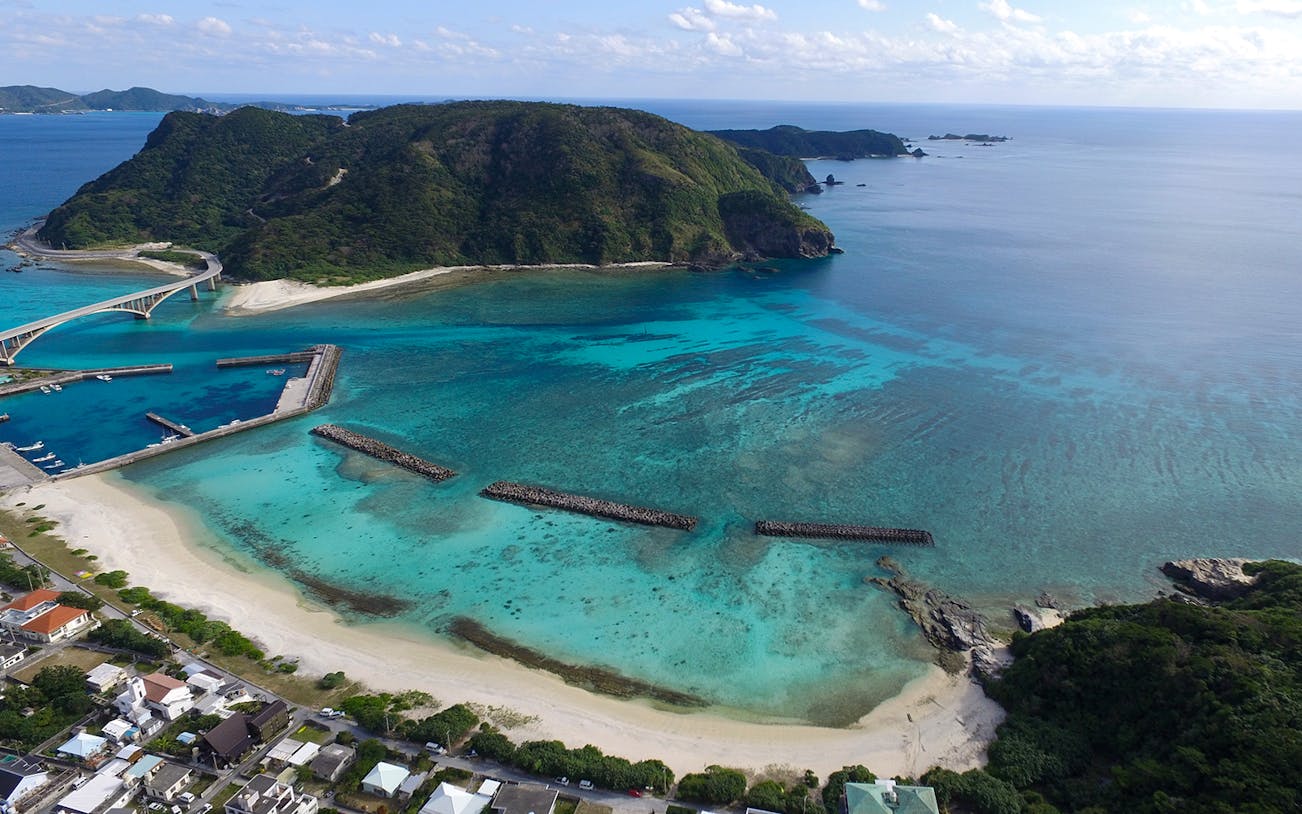Aerial view of Kerama Chibishi Island's turquoise waters and coastline, ideal for snorkeling tours.