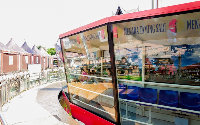 Menara Taming Sari cabin with tourists seated, Melaka.