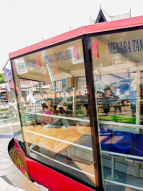 Menara Taming Sari cabin with tourists seated, Melaka.