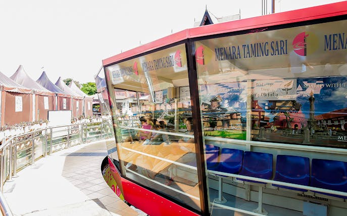 Menara Taming Sari cabin with tourists seated, Melaka.