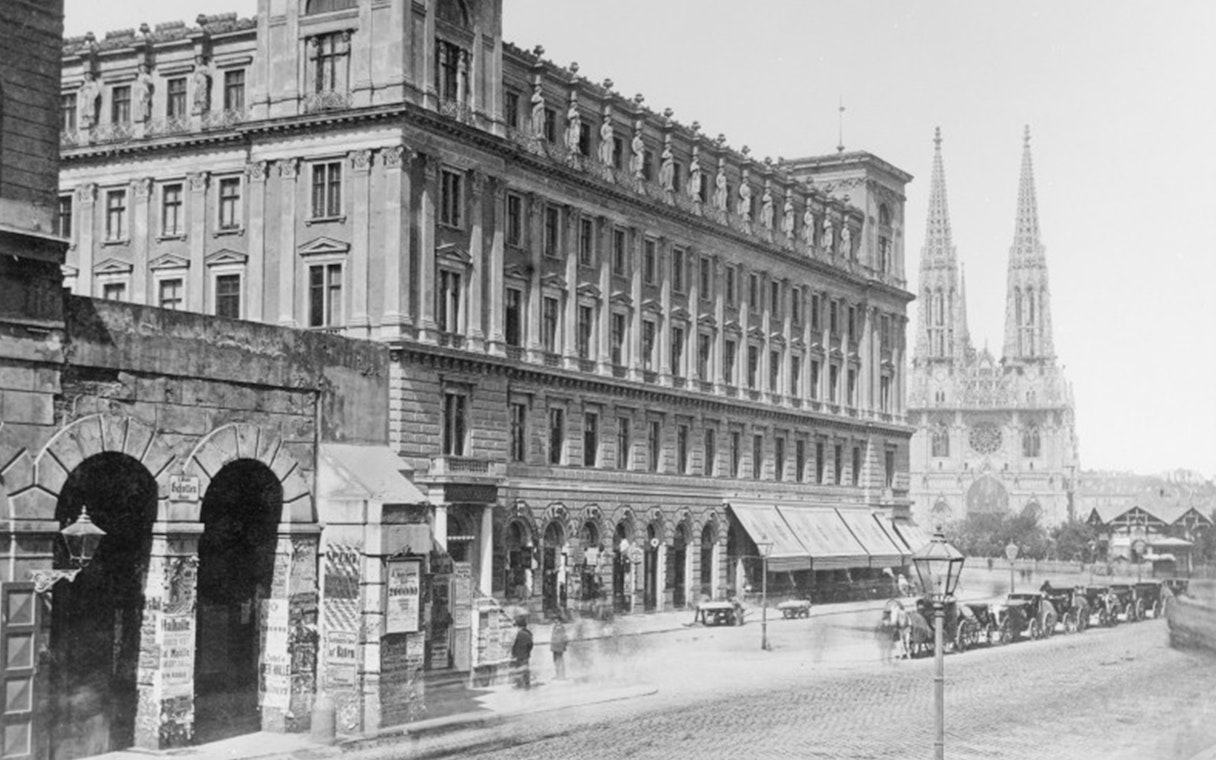 Historic street view near Jewish Museum Vienna with Votivkirche in the background.