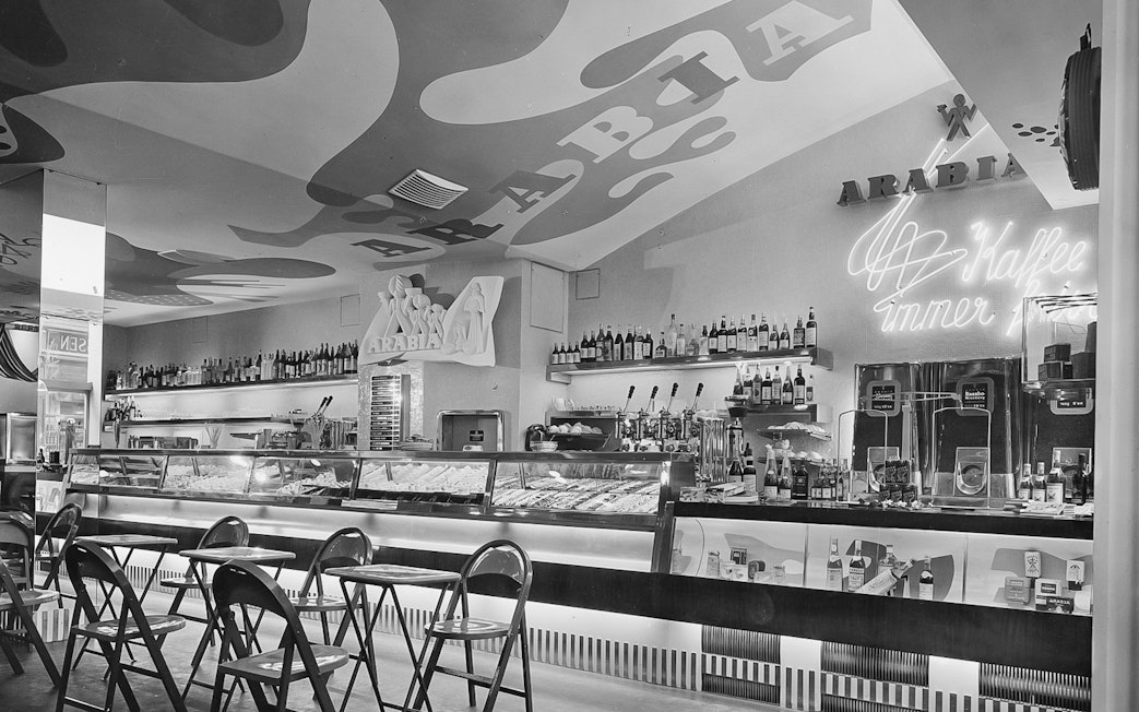 Bar area with chairs and neon sign at Jewish Museum Vienna.