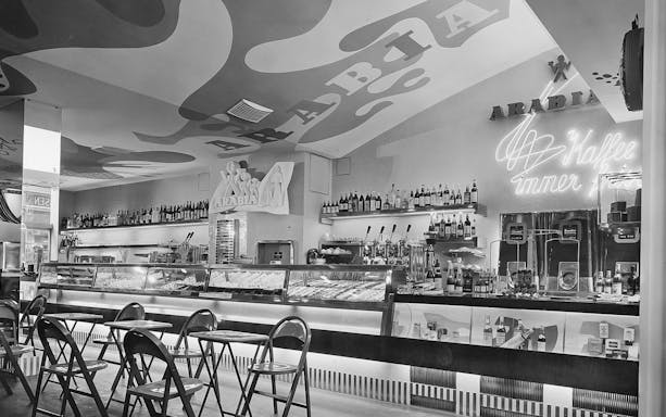 Bar area with chairs and neon sign at Jewish Museum Vienna.