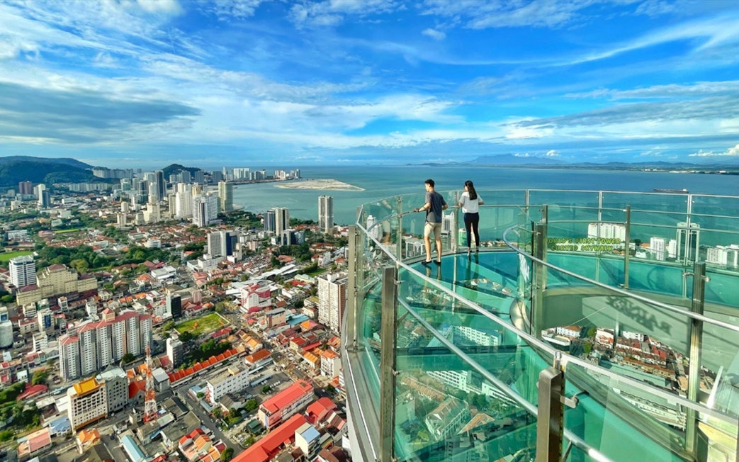 Skywalk view from The Top Penang overlooking cityscape and coastline.