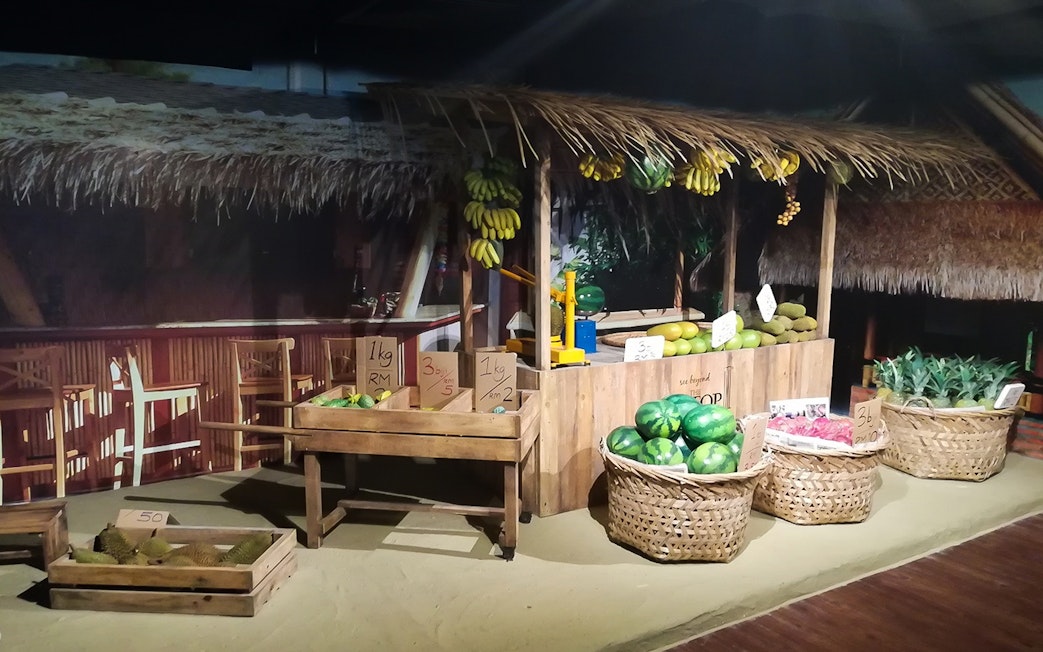 Fruit stall with bananas, watermelons, and durians at The Top Penang's Jurassic Research Centre.