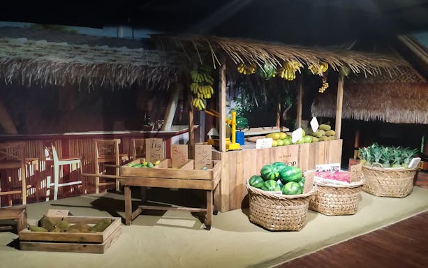 Fruit stall with durians, bananas, and watermelons at Penang State Gallery.