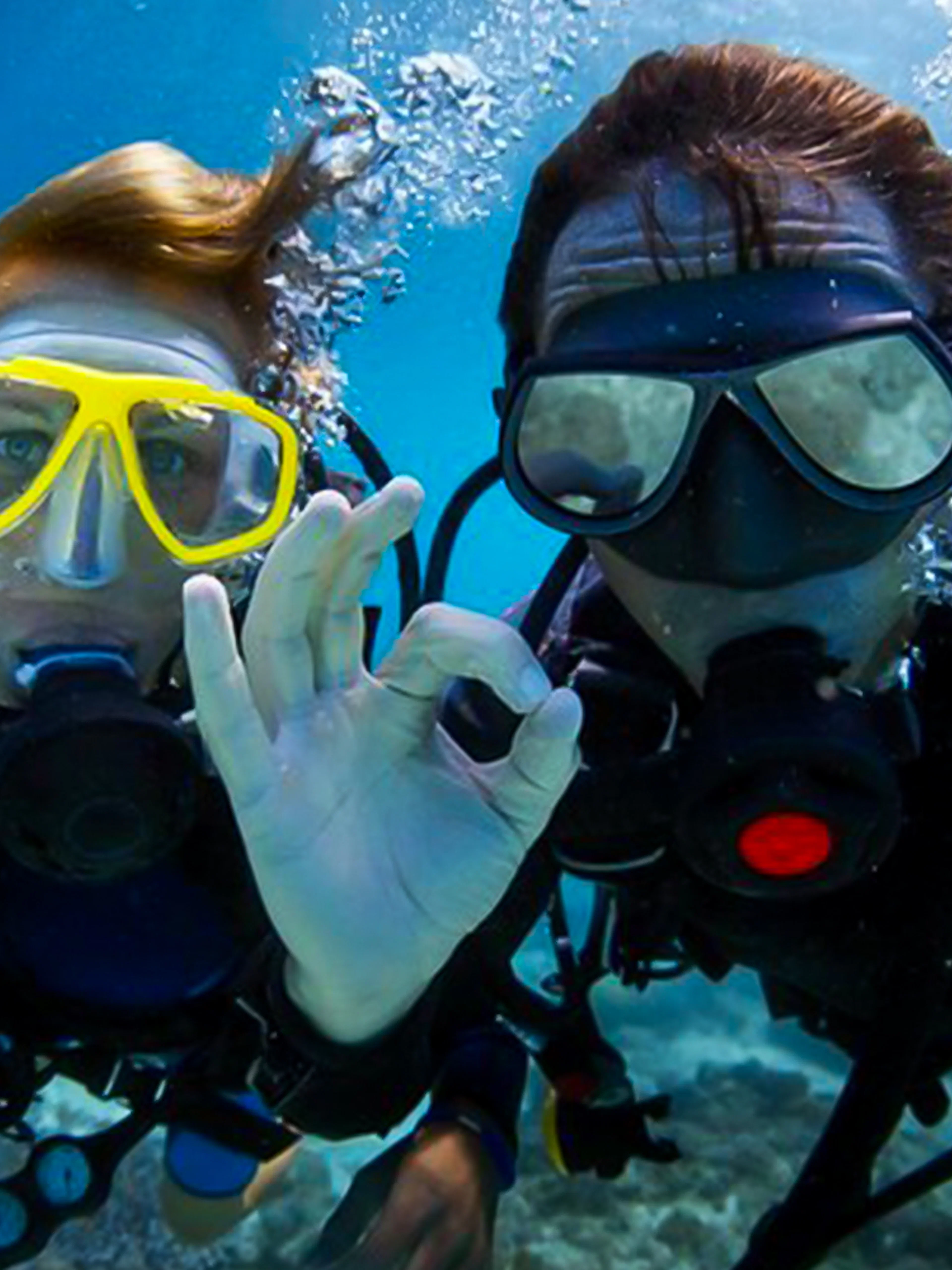 Scuba divers underwater giving OK sign in Dubai.