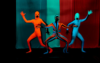 Performers in vibrant costumes at WOW Show Black Light Theater.