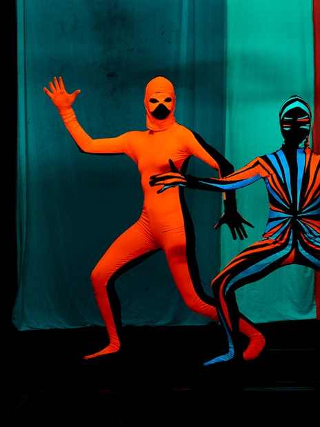 Performers in vibrant costumes at WOW Show Black Light Theater.