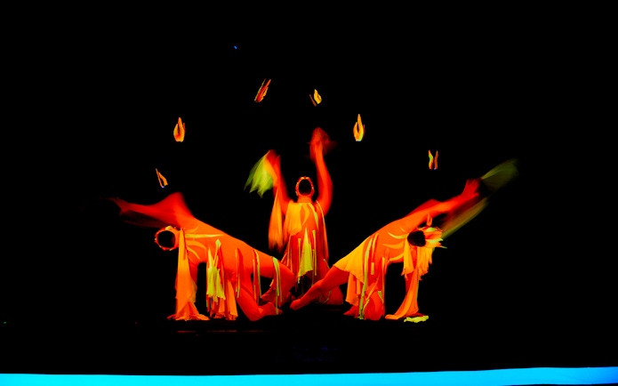 Performers in vibrant costumes at WOW Show Black Light Theater.