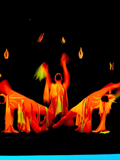 Performers in vibrant costumes at WOW Show Black Light Theater.