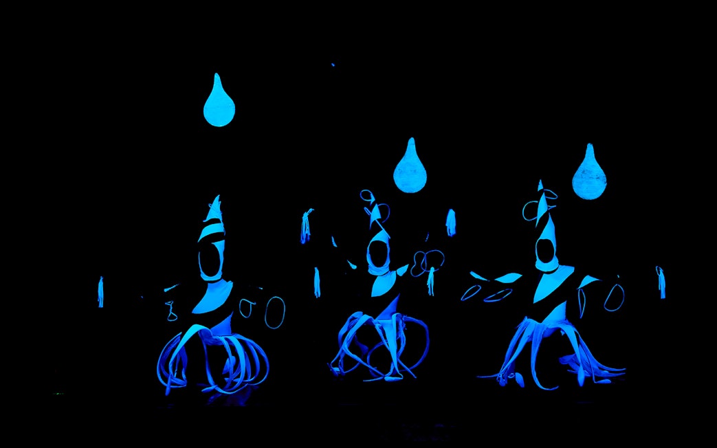 Performers in glowing costumes at WOW Show Black Light Theater.