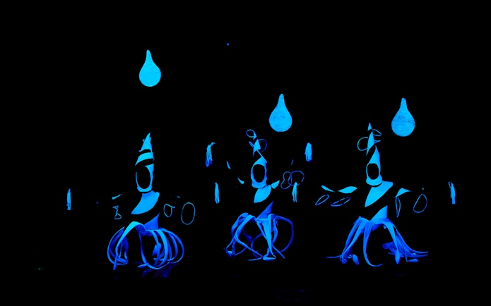 Performers in glowing costumes at WOW Show Black Light Theater.
