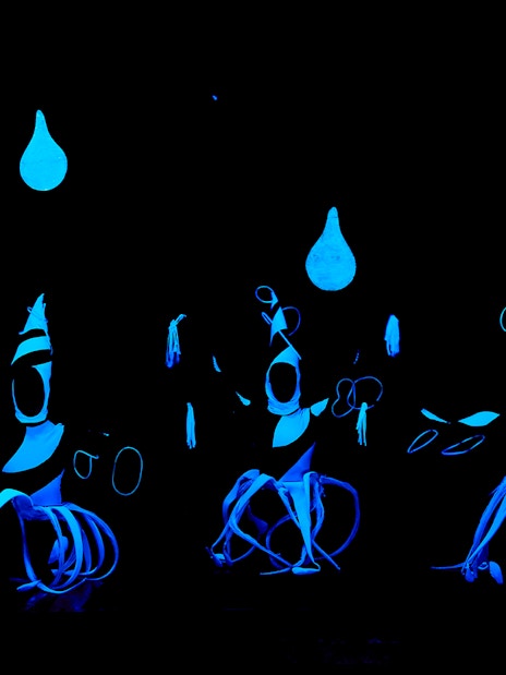 Performers in glowing costumes at WOW Show Black Light Theater.