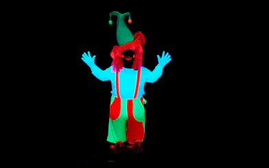 Performer in neon costume at WOW Show Black Light Theater.