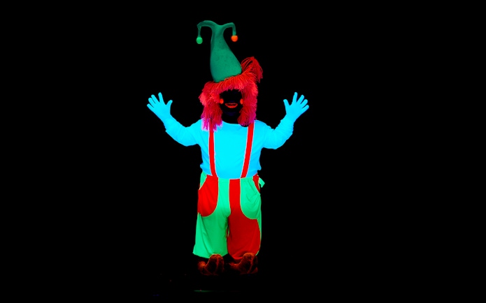 Performer in neon costume at WOW Show Black Light Theater.