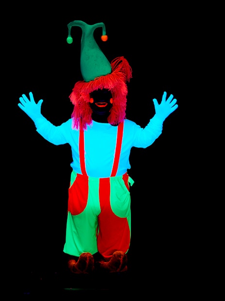 Performer in neon costume at WOW Show Black Light Theater.