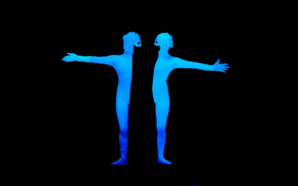 Performers in glowing costumes at WOW Show Black Light Theater.