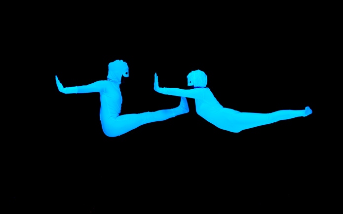Performers in glowing blue suits at WOW Show Black Light Theater.
