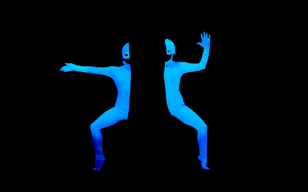 Performers in glowing blue suits at WOW Show Black Light Theater.