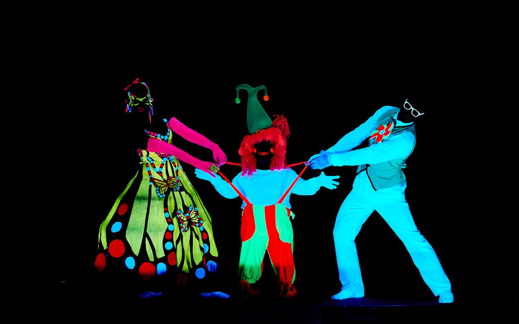 Performers in neon costumes at WOW Show Black Light Theater.