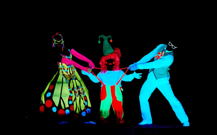 Performers in neon costumes at WOW Show Black Light Theater.