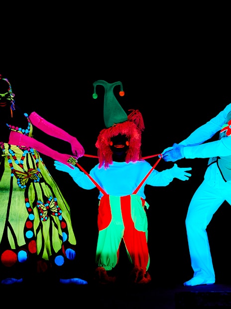 Performers in neon costumes at WOW Show Black Light Theater.
