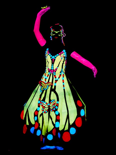 Performer in colorful costume at WOW Show Black Light Theater.