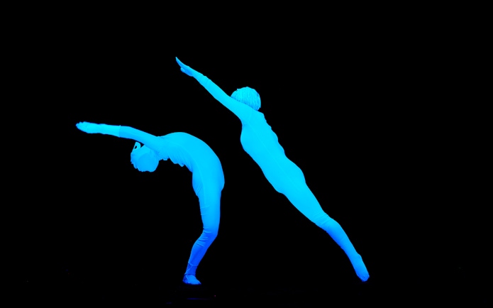 Performers in glowing costumes at WOW Show Black Light Theater.