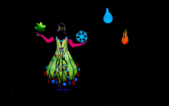 Performer in colorful costume at WOW Show Black Light Theater.