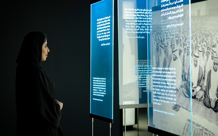 Visitor viewing historical exhibit at Al Shindagha Museum, Dubai.